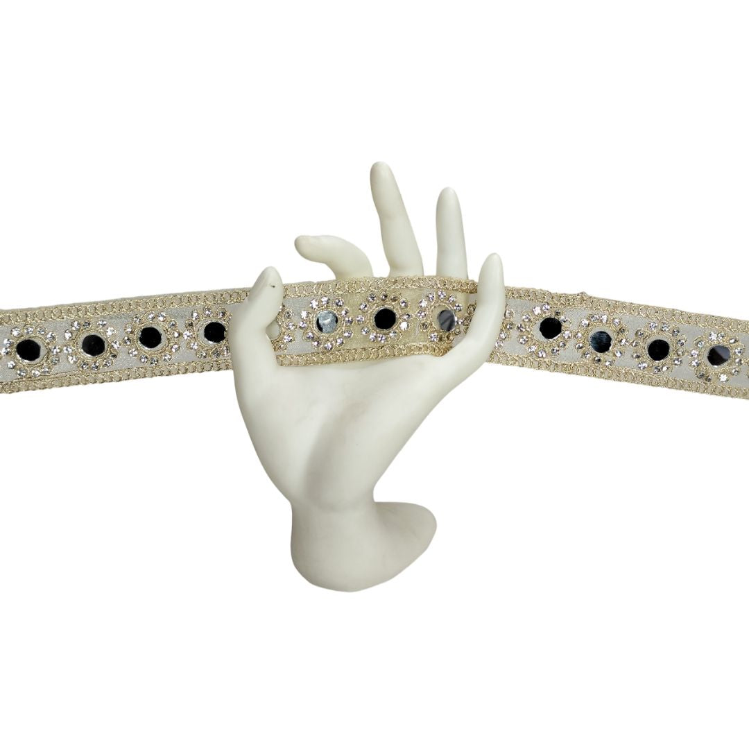 Decorative belt with gemstones held by a mannequin hand on a white background