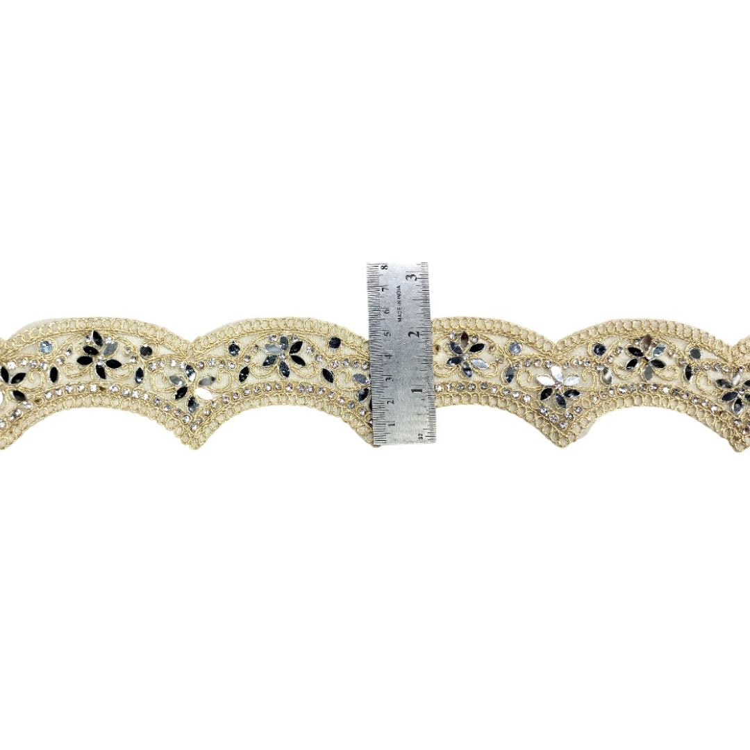 Decorative lace trim with a ruler for scale on a white background