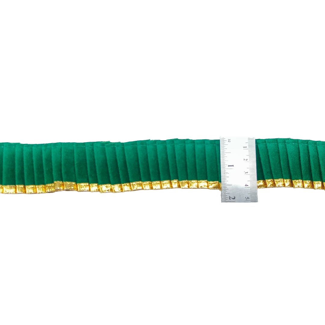 Green pleated trim with gold edge and a ruler for scale on a white background