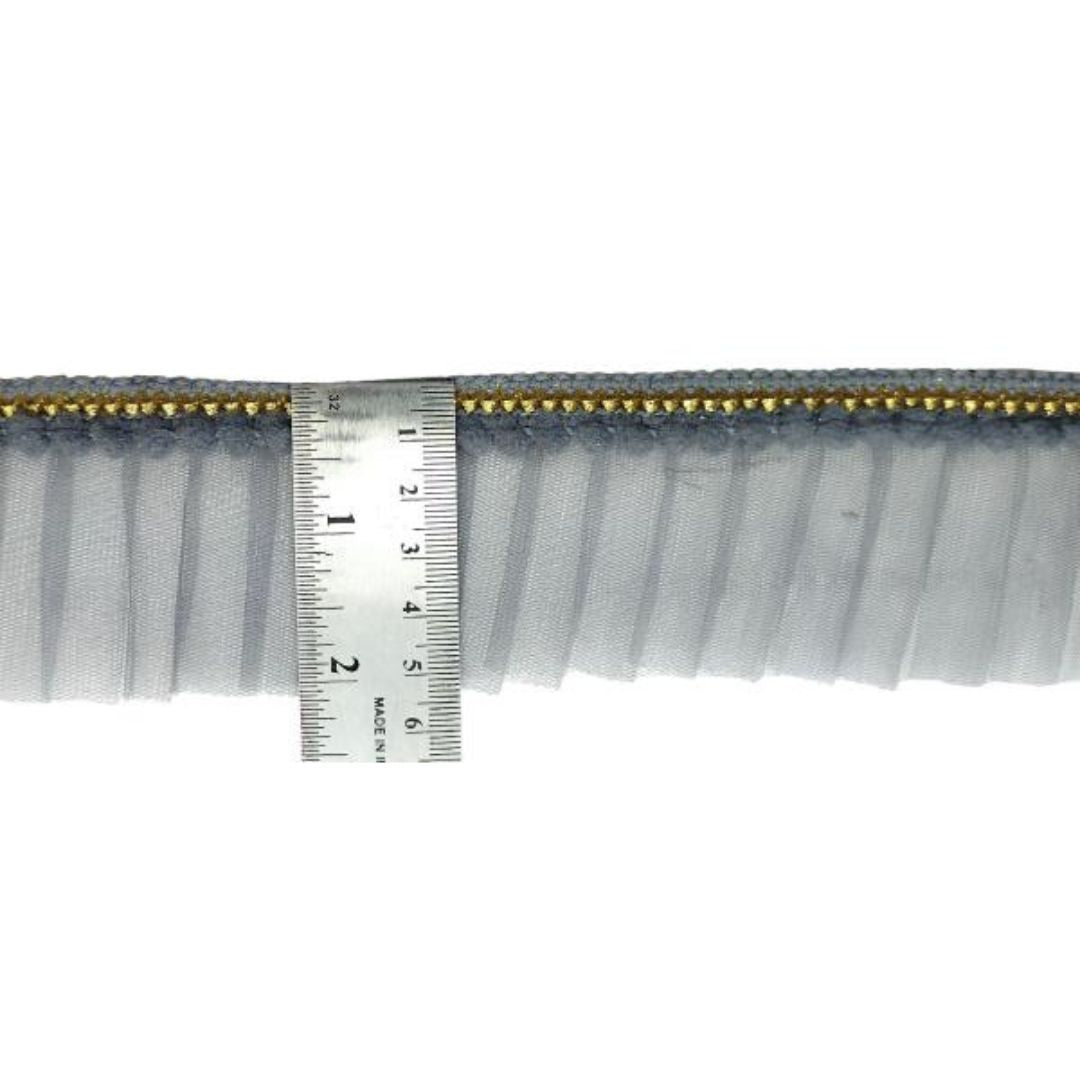 Close-up of a fabric trim with a ruler for scale on a white background