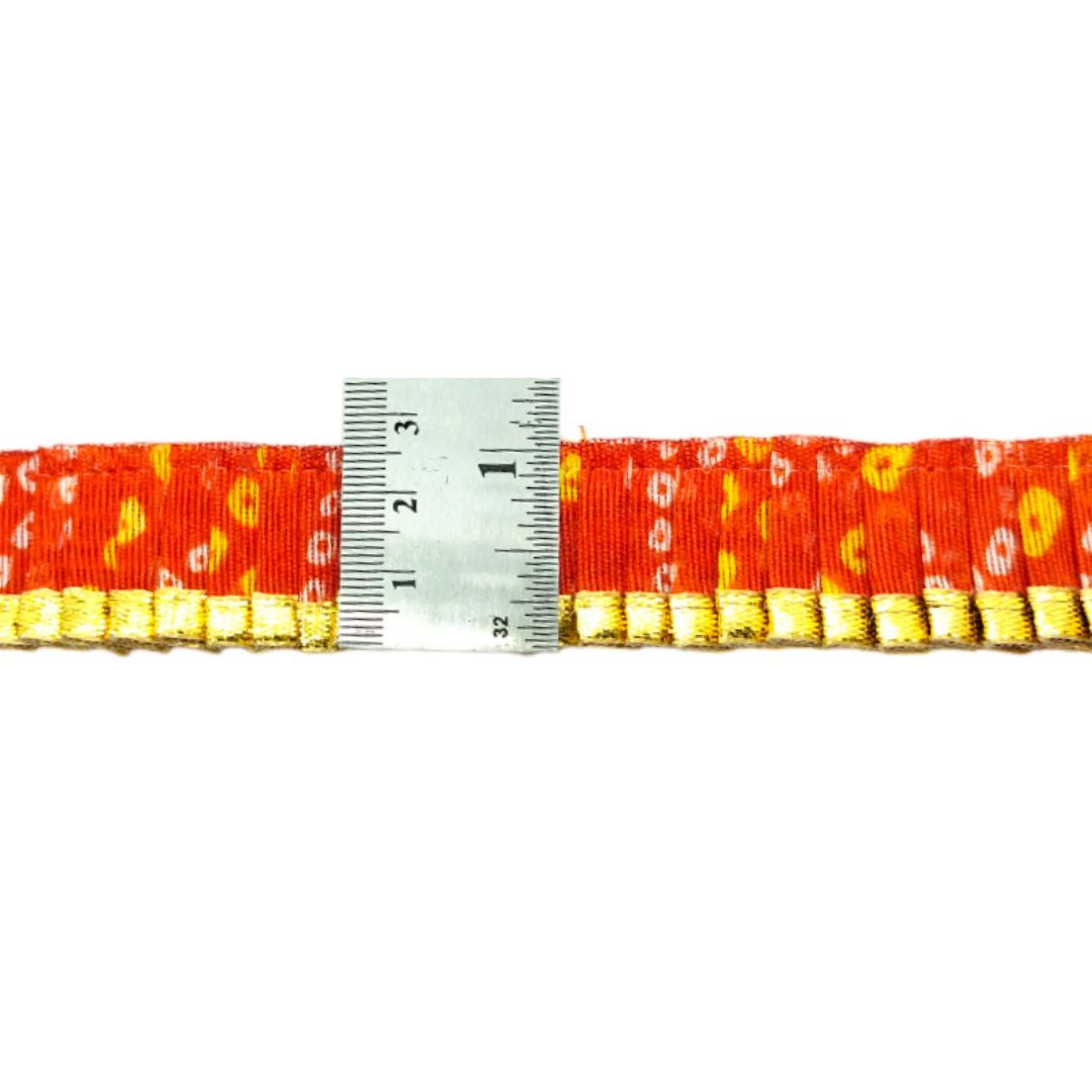 Red belt with gold pattern and a measuring tape on a white background
