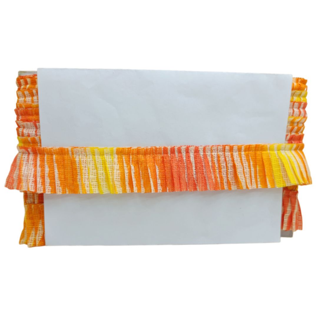 White clutch with orange and yellow ruffled trim on a white background