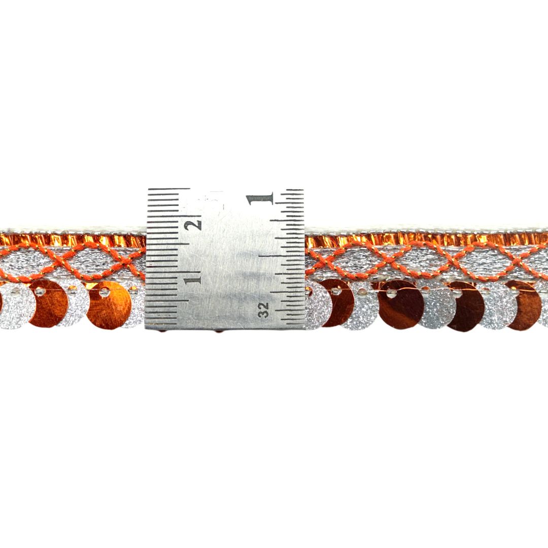 Decorative ribbon with circular patterns and a ruler for scale on a white background