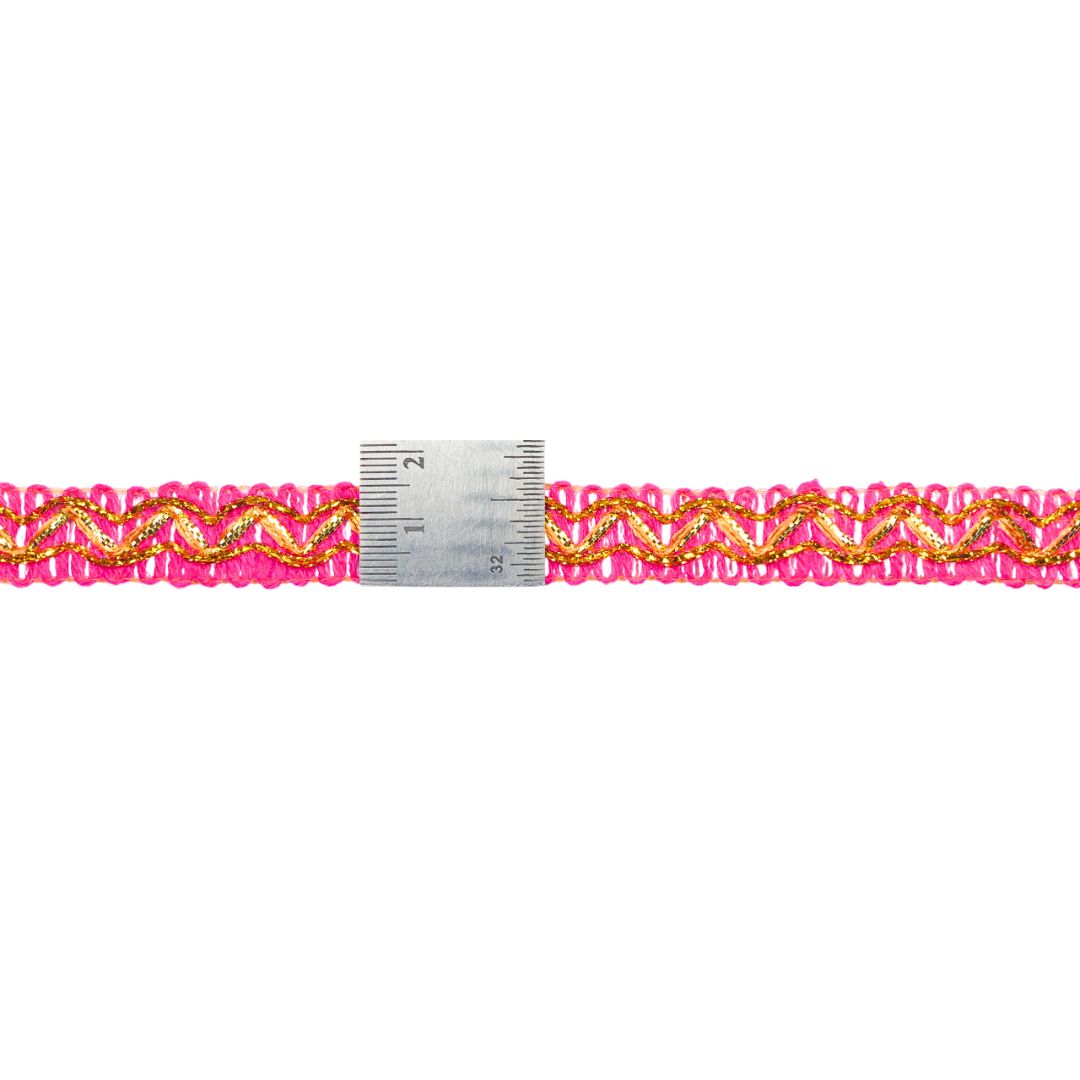 Gold and pink braided trim with a measuring tape for scale on a white background